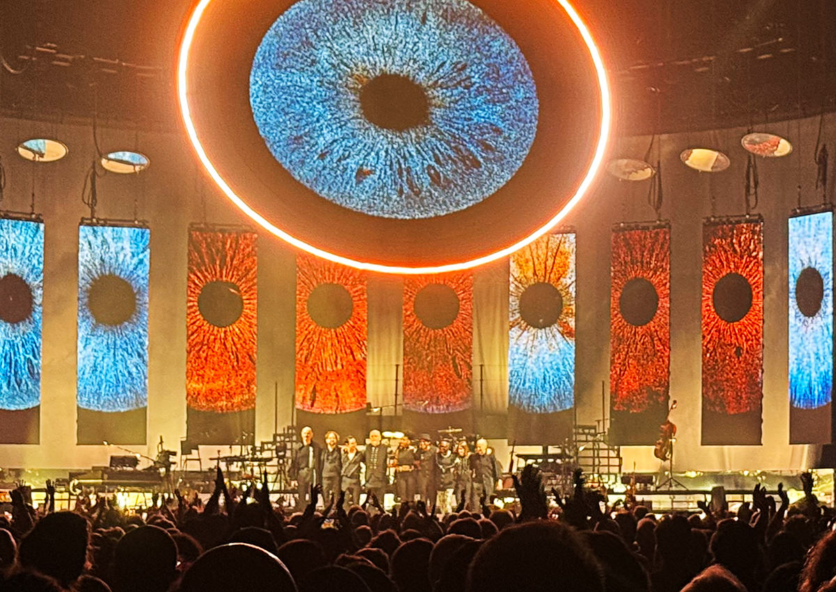 Peter Gabriel and his band taking a bow in front of a lot of eyeballs projected on screens for the song In Your Eyes.
