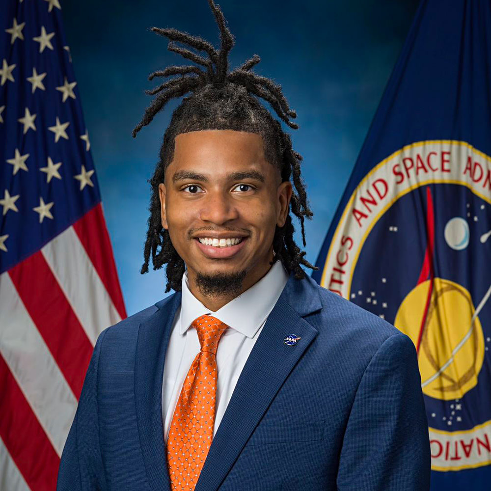 Tyrone Jacobs and his natural hair in front of an American flag for his NASA headshot.