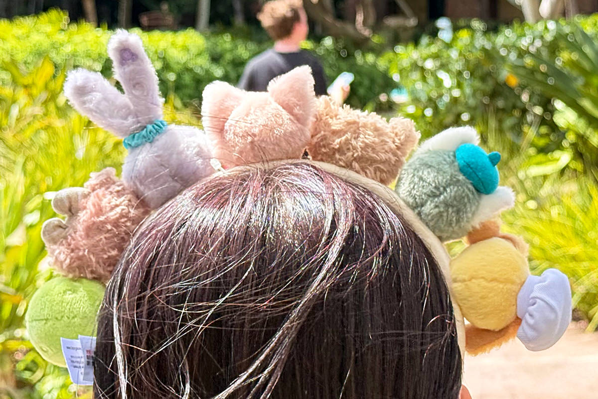 Woman wearing a headband with all the Duffy characters on it.