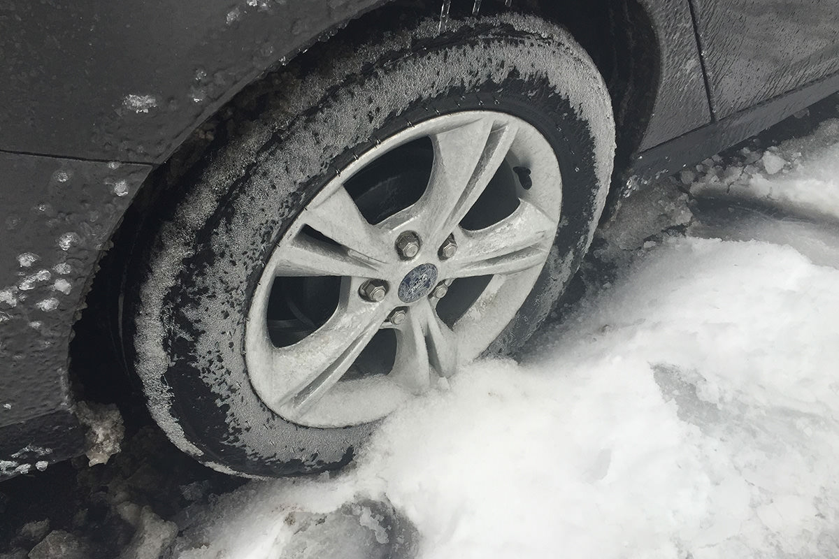 Car tire frozen to the ground.
