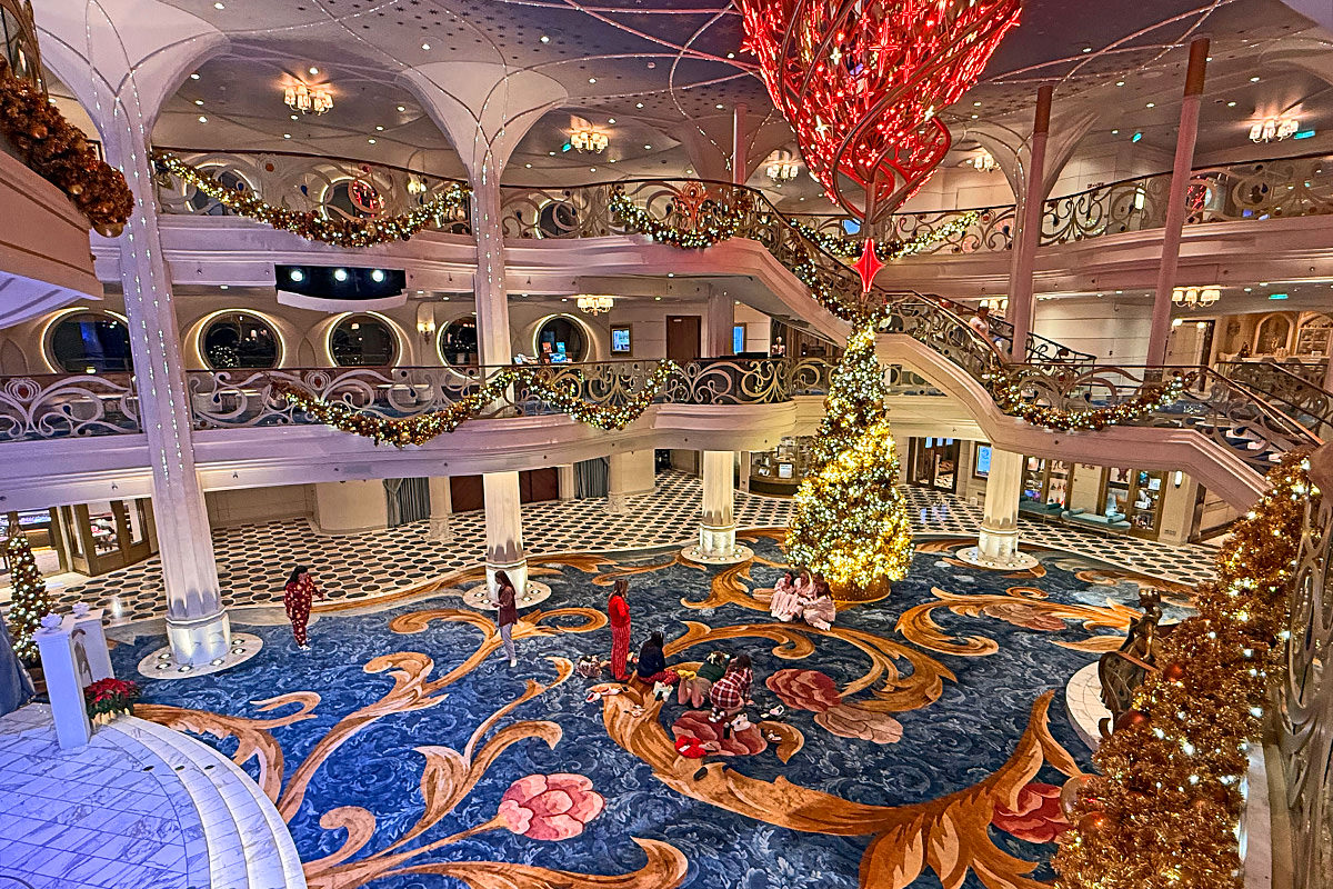 A few scattered people in the atrium of the Disney Wish