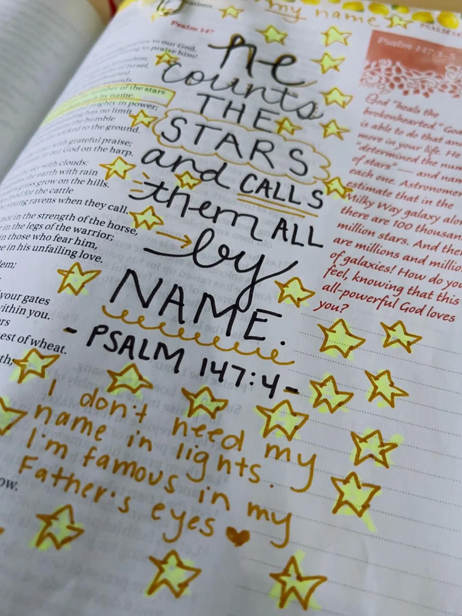 A Bible page with decorations and writing all over it.