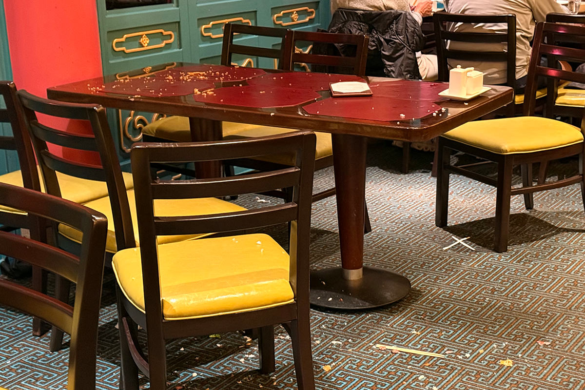 Disaster floor and table covered with food everywhere.